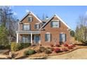 Attractive two-story brick home with a welcoming front porch and beautifully landscaped front yard at 1345 Hilltop Overlook Dr, Marietta, GA 30062