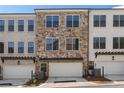 Townhome with stone and painted brick facade, garage, and well-maintained landscaping at 160 Chiswick Cir # 2, Alpharetta, GA 30009