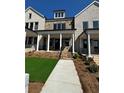 Inviting townhome featuring a stone facade, covered porch with white columns and a well-maintained lawn at 160 Chiswick Cir # 2, Alpharetta, GA 30009