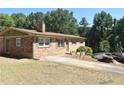 Charming brick ranch with green shutters, mature trees, and a long driveway at 3400 Scott Dr, Austell, GA 30106