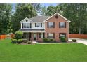 Well-maintained two-story home with a manicured lawn and mature landscaping at 5399 Emily Cir, Ellenwood, GA 30294