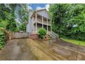 Two-story home featuring double balconies, a side chimney, and lush landscaping at 1103 Coleman Sw St, Atlanta, GA 30310