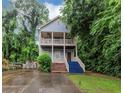 Two-story home featuring double balconies and a landscaped front yard surrounded by mature trees at 1103 Coleman Sw St, Atlanta, GA 30310