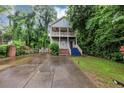 Inviting two-story home with a double balcony, lush landscaping, and a spacious driveway at 1103 Coleman Sw St, Atlanta, GA 30310