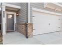 Close up of a townhome's garage and front door with brick and gray color palette at 323 Hayden Circle Cir, Woodstock, GA 30189