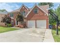 Two-story brick home with a basketball hoop, attached two-car garage, and well-kept landscaping at 118 Surge Stone Ln, Stockbridge, GA 30281