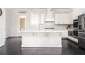 Modern kitchen boasts white cabinets, stainless appliances, and large center island at 2026 Forte Lane, Alpharetta, GA 30009