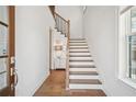 Bright entryway featuring hardwood floors, staircase with wooden treads and white risers, and modern lighting at 6838 Prelude Dr, Atlanta, GA 30328