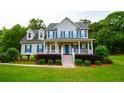 Traditional two-story home featuring blue shutters, a covered front porch, and lush green lawn at 855 Hood Rd, Fayetteville, GA 30214