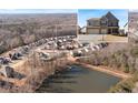 Picturesque aerial view of a neighborhood with homes surrounding a tranquil lake and lush greenery at 5915 Partners Pass, Cumming, GA 30028