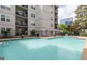 Community swimming pool with lounge area and a view of nearby buildings and landscaping at 1075 Peachtree Walk # A205, Atlanta, GA 30309