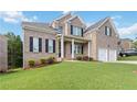 Beautiful two-story brick home featuring a covered porch and lush green lawn at 2031 Broadmoor Way, Fairburn, GA 30213