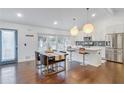 Bright kitchen features a dining table, white cabinets, stainless steel appliances, and stylish pendant lighting at 2344 Belmont Dr, Decatur, GA 30032