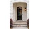 Inviting front entrance features a stone archway, elegant glass door, and a view into the home's interior at 10580 Grandview Sq, Johns Creek, GA 30097