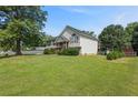 Two-story home with a large yard, mature trees, and neutral siding on a sunny day at 47 Powder Springs St, Hiram, GA 30141