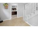 Hallway with light wood floors and stairs leading to the upper level at 115 Leaf Lake Dr, Suwanee, GA 30024