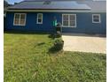 Blue home's backyard featuring a solar-paneled roof and well-maintained lawn at 160 Springdale Ct, Newborn, GA 30056