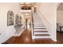 Elegant foyer with hardwood floors, staircase, and decorative console table at 817 Nevis Way, Mcdonough, GA 30253