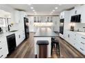 Modern kitchen with white cabinets, black appliances, a center island, and hardwood floors at 2900 Orchard Sw Rd, Conyers, GA 30094