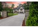Gated driveway leading to a two-story brick home with manicured lawn at 4955 Chamblee Dunwoody Rd, Dunwoody, GA 30338