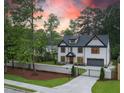Gated driveway leading to a two-story brick home with manicured lawn and colorful sunset at 4955 Chamblee Dunwoody Rd, Dunwoody, GA 30338