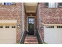 Charming front entrance with a black front door, brick steps, and a black metal handrail at 565 Rose Garden Ln, Alpharetta, GA 30009