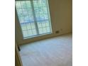 Cozy bedroom featuring a large window offering natural light, and neutral carpet at 1481 Yates Cv, Lawrenceville, GA 30043