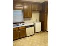 This kitchen features stained wood cabinets, a double basin sink, and laminate countertop at 1481 Yates Cv, Lawrenceville, GA 30043