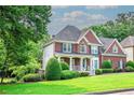 Inviting two-story home featuring a cozy front porch and well-manicured green lawn at 1409 Echo Mill Dr, Powder Springs, GA 30127