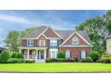Charming two-story brick home featuring a manicured lawn, inviting porch and blue shutters at 1409 Echo Mill Dr, Powder Springs, GA 30127