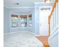 Inviting living room with a staircase, featuring a bay window with woven shades and marble-look flooring at 2594 Laurel Nw Cir, Atlanta, GA 30311