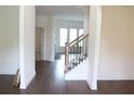 Spacious entry featuring gleaming hardwood floors and a staircase with iron spindles at 150 Canal St, Hampton, GA 30228