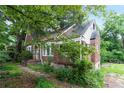 Brick home boasts white-trimmed windows, a quaint front entrance, and established landscaping at 1699 Emerald Sw Ave, Atlanta, GA 30310