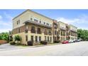 Multi-story townhomes featuring brick and stucco exterior finishes, with small front balconies and street parking at 384 16Th Nw St # 1, Atlanta, GA 30363