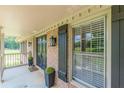 Inviting front porch with brick accents, stylish black door with decorative lanterns, and black window shutters at 7928 S Giles Rd, Douglasville, GA 30135