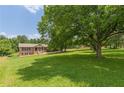Spacious front yard featuring a brick home, mature trees that offer shade, and a well-maintained lawn at 7928 S Giles Rd, Douglasville, GA 30135