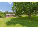 Spacious front yard with mature trees surrounding a charming brick home at 7928 S Giles Rd, Douglasville, GA 30135