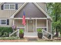 Inviting front porch with decorative plants, an American flag, and the house number prominently displayed at 890 Lake Dr, Snellville, GA 30039