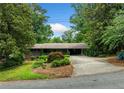 Charming brick home with mature trees and landscaping, featuring a covered carport at 1138 Berkeley Rd, Avondale Estates, GA 30002