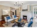 Stylish living room featuring a cozy fireplace, modern decor, hardwood floors, and abundant natural light at 1371 N Highland Ne Ave, Atlanta, GA 30306