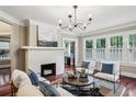 Bright living room with a white brick fireplace, hardwood floors, neutral tones, and multiple windows at 1371 N Highland Ne Ave, Atlanta, GA 30306