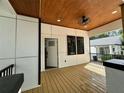 Close-up of a covered front porch with wood flooring, modern ceiling fan, and view of adjacent house at 1766 W Lyle W Ave, College Park, GA 30337
