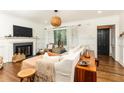 Cozy living room with a fireplace, hardwood floors, and a large window with natural light at 1443 Fama Ne Dr, Atlanta, GA 30329