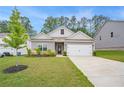 Cozy home with neat landscaping, a two-car garage, and classic gray siding under a clear sky at 225 Limestone Cir, Conyers, GA 30013
