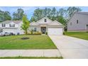 Inviting gray home with a well-maintained lawn, complemented by lush greenery and a paved driveway at 225 Limestone Cir, Conyers, GA 30013