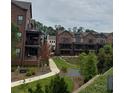 View of brick townhomes with charming balconies and landscaped yard at 435 Chiswick Cir # 21, Alpharetta, GA 30009