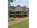 Exterior view of new brick townhome with balconies and manicured lawn at 435 Chiswick Cir # 21, Alpharetta, GA 30009