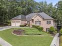 Beautiful brick house with well-maintained landscaping and an attached two-car garage at 569 Fairway Dr, Woodstock, GA 30189