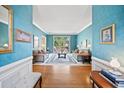 Bright living room with hardwood floors and blue walls with large window views to the exterior at 569 Fairway Dr, Woodstock, GA 30189