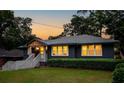 Inviting home exterior at dusk with glowing windows, a dark exterior, and luscious green lawn at 1494 May Se Ave, Atlanta, GA 30316